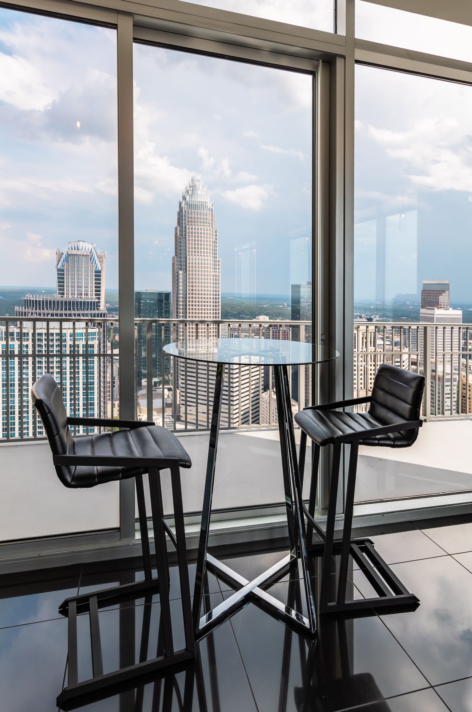The Vue Charlotte high rise apartment featuring a table and chairs in front of floor to ceiling windows