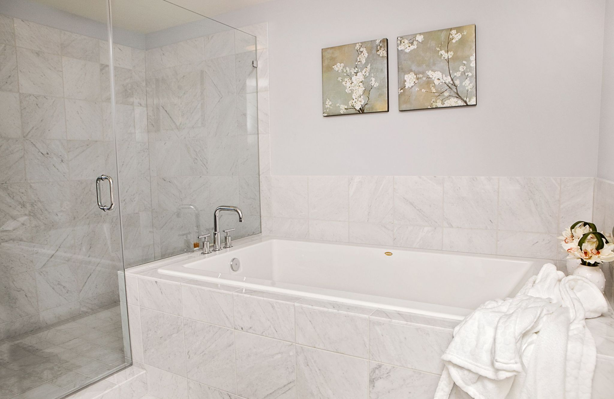 The Vue at Charlotte, NC luxury apartment bathroom with glass-enclosed shower with tile and large soaking tub